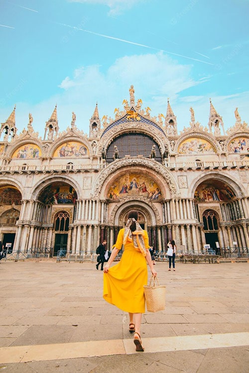 Venice | Luxury Italy Travel Agent woman yellow sundress with straw hat walking saint mark basilica 259348 19428 min . Luxury Italy Travel Agent